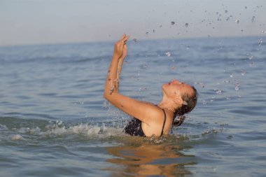 Denizde su sıçramalarına ile yaşlı kadın.