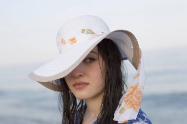 Deniz arka plan üzerinde şapkalı güzel kız