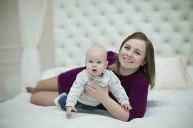 Anne ile küçük oğlu yatağın üstünde. Anne ve bebek