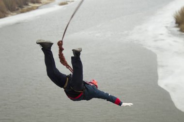 Beyaz Rusya, Gomel, 08 Mart 2019. Köprü için ip atlama. Ropejumping.A adam büyük bir yükseklikten atlar ve nehrin üzerinde bir ip üzerinde gökyüzünde uçar. Aşırı tutku