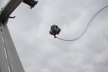 Beyaz Rusya, Gomel, 08 Mart 2019. Köprü için ip atlama. Ropejumping.A adam büyük bir yükseklikten atlar ve ip gökyüzünde uçar. Aşırı tutku