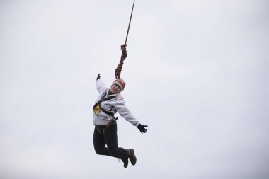 Beyaz Rusya, Gomel, 08 Mart 2019. Köprü için ip atlama. Ropejumping.An yaşlı kadın büyük bir yükseklikten atlar ve ip gökyüzünde uçar. Emekli aşırı hobi