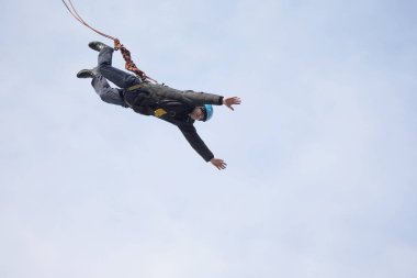 Beyaz Rusya, Gomel, 08 Mart 2019. Köprü için ip atlama. Ropejumping.A adam büyük bir yükseklikten atlar ve aşağı bir ip üzerinde gökyüzünde uçar. Aşırı tutku