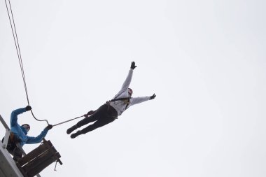 Beyaz Rusya, Gomel, 08 Mart 2019. Köprü için ip atlama. Ropejumping.A kadın büyük bir yükseklikten atlar ve ip gökyüzünde uçar. Aşırı tutku