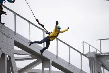 Beyaz Rusya, Gomel, 08 Mart 2019. Köprü için ip atlama. Ropejumping.Dangerous Hobiler. Cesur kadın köprüsünden atlama