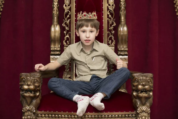 A child with a crown in the royal chair