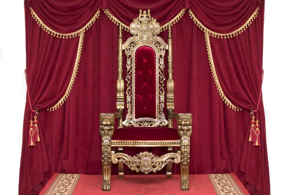 Red royal chair on a background of red curtains. Place for the king. Throne