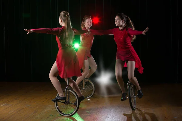 三个单轮车的女孩在舞台上表演 自行车上的马戏团艺术家 — 图库照片