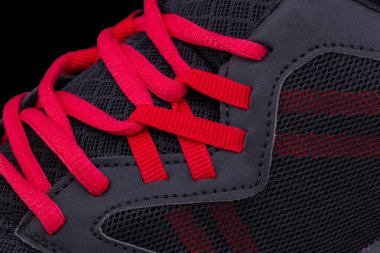 Kırmızı dantelli siyah bir spor ayakkabının bir parçası. Spor ayakkabı doku