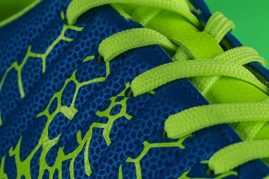 Yeşil dantelli mavi bir spor ayakkabının parçası. Spor ayakkabı doku