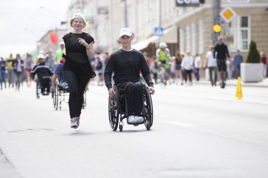 Belarus, Gimel şehri, 3 Temmuz 2019. Gençlik Festivali. Tekerlekli sandalye yarışları. Özürlü ve sağlıklı insanlar birlikte maraton koşuyor.