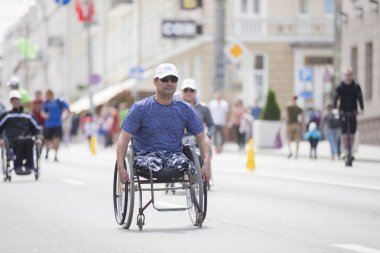 Belarus, Gimel şehri, 3 Temmuz 2019. Gençlik Festivali. Tekerlekli sandalye yarışı. Tekerlekli sandalyedeki bir adam maratonda yarışıyor.
