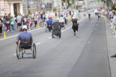 Belarus, Gimel şehri, 3 Temmuz 2019. Gençlik Festivali. Tekerlekli sandalye yarışı. Tekerlekli sandalyedeki insanlar maratonda yarışıyor.