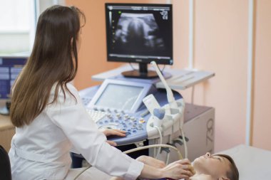 Gomel şehri, Belarus, 31 Mayıs 2017. Şehir Hastanesi. Ultrason teşhis odası. Doktor çocuğa tiroid bezi ultrasonu teşhisi koyuyor. Tiroid ultrasonu