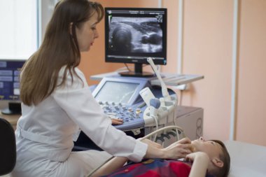 Gomel şehri, Belarus, 31 Mayıs 2017. Şehir Hastanesi. Ultrason teşhis odası. Doktor çocuğa tiroid bezi ultrasonu teşhisi koyuyor. Tiroid ultrasonu