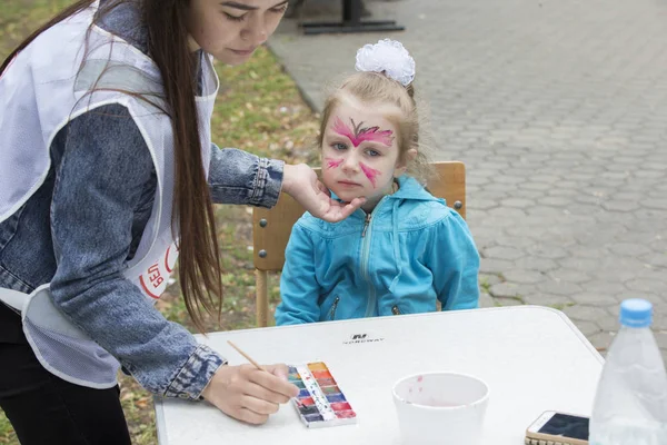 Belarus, Gimel şehri, 3 Temmuz 2019. Gençlik Festivali. Küçük kız yüz resmi çiziyor.