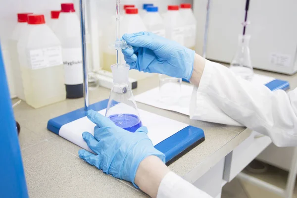 一个戴着蓝色橡胶手套的技术人员手里拿着一个烧瓶 制药业 化学实验室 — 图库照片