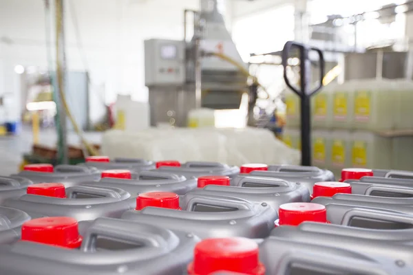 Plastic containers with lids on the background of chemical production.