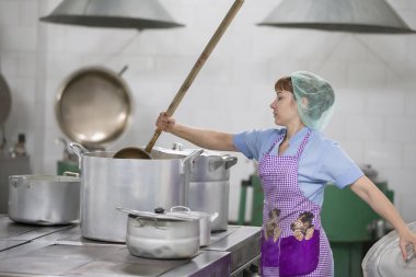 Belarus, Gomel, 2 Haziran 2017.Hastanede endüstriyel mutfak. Cook yemek hazırlar. Büyük tava ve bir kepçe ile pişirin. Kepçeli mutfak işçisi. Şef profesyonel