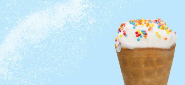 Çok renkli sos lu waffle bardağına yakın çekim dondurma. Beyaz kar taneleri ile mavi bir arka plan tatlı tatlı