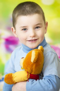 Dört yaşındaki bir çocuğun oyuncak ayıyla portresi..