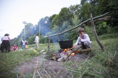 Beyaz Rusya, Gomel şehri, 08 Temmuz 2018. Tatil Ivan Kupala. Yangının yanında ulusal Belarus giysileri giyen bir çocuk