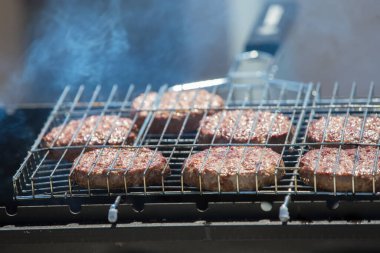 Hamburger için kızarmış köfte. Izgara et. Dumanda bir parça et.