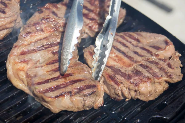 Izgara et. Pişirme sırasında bir parça biftek..