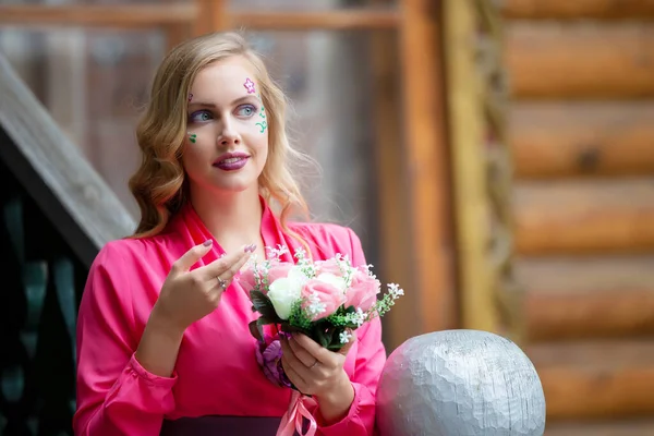 Lussuosa ragazza bionda in abiti luminosi con un bouquet. — Foto Stock