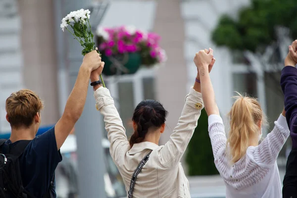 Belarús contra el dictador. Mujeres con flores levantaron sus manos. — Foto de Stock