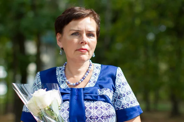 A middle-aged woman with flowers.The woman is fifty years old. — Stock Photo, Image