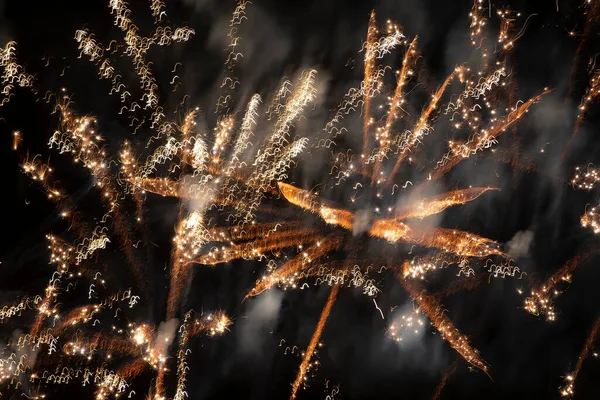 Fuochi d'artificio d'oro sfocati luci su uno sfondo nero. — Foto Stock