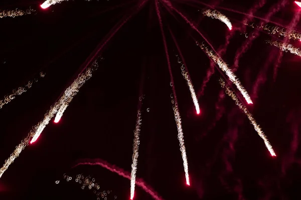 Fogos de artifício raios de luz de vermelho sobre um fundo preto. — Fotografia de Stock