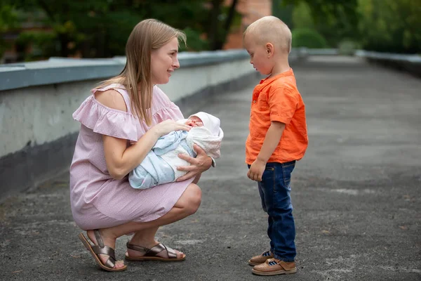 Mutter zeigt ihrem Sohn eine neugeborene Schwester. — Stockfoto