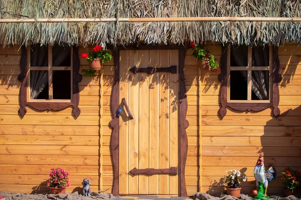 Fond mur en bois d'une maison avec une fenêtre et un toit de chaume. — Photo