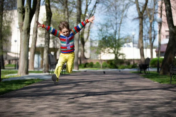 Bambino felice sta saltando su per una passeggiata nel parco. — Foto Stock