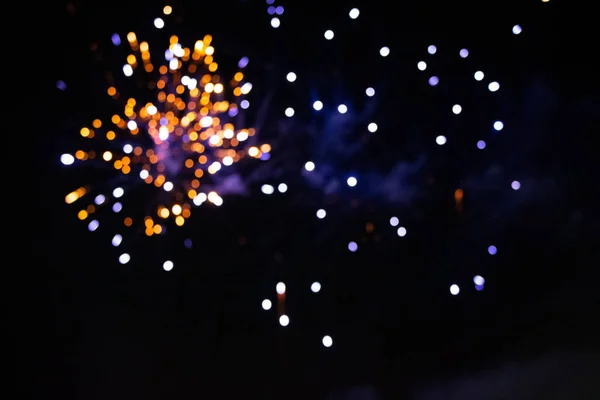 Pontos bokeh multicoloridos de fogos de artifício em fundo preto. — Fotografia de Stock