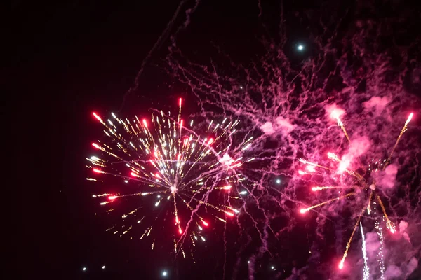 Manchas cor de rosa de fogos de artifício em um fundo preto. Fundo festivo. — Fotografia de Stock