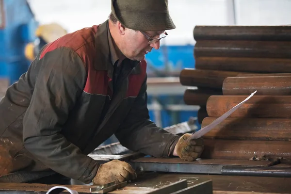 Industria dei metalli. Lavoratore in una fabbrica con tubi metallici.. — Foto Stock