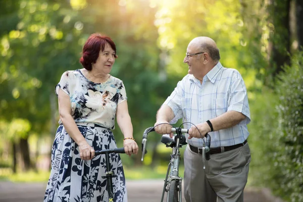 Щаслива літня пара з велосипедом. Красивий чоловік і жінка старші громадяни. Чоловік і дружина старого віку на прогулянку . — стокове фото