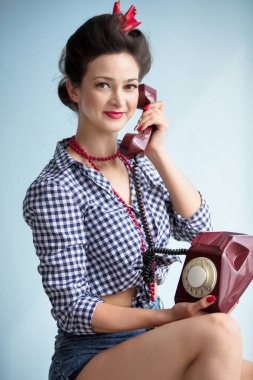 50 'lerin tarzında bir kadın. Retro kadının elinde telefon var..