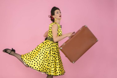 Pembe arka planda eski bir bavulu olan Retro Girl.