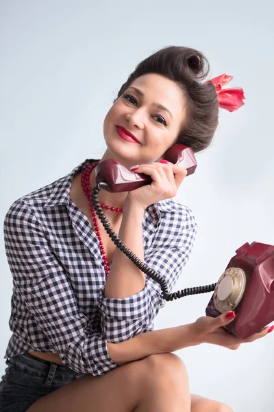 Kobieta w stylu lat pięćdziesiątych. Piękna dziewczyna retro ze starym telefonem. — Zdjęcie stockowe