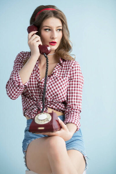 Женщина в стиле пятидесятых. Красивая ретро-женщина со старым телефоном.