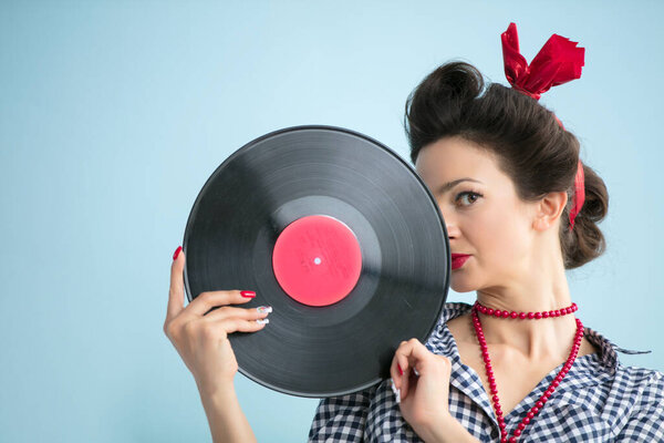 Retro woman in fifties style holds a musical record.