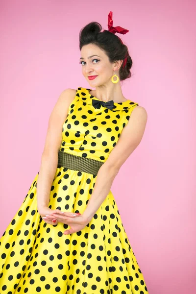 Retro lány. Gyönyörű nő egy ruhát polka pöttyök fényes háttér. — Stock Fotó