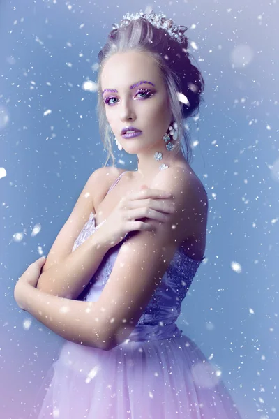 Modelo de menina na imagem da rainha de neve em um fundo de neve.. — Fotografia de Stock