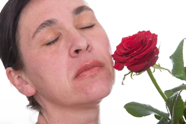 一个带着玫瑰的成熟女人的近视脸。40岁后皮肤老化的迹象 — 图库照片