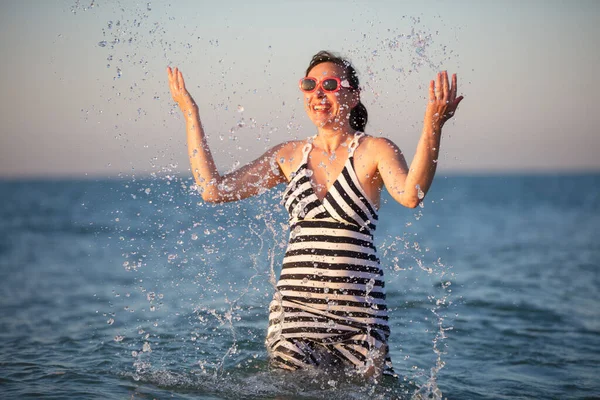 Szczęśliwa starsza kobieta na morzu. Splash wody morskiej na wakacjach. — Zdjęcie stockowe