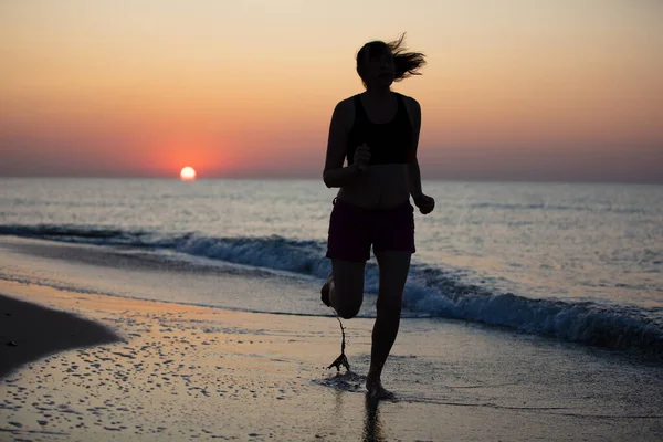 Sylwetka sportowca na tle wschodu słońca na morzu — Zdjęcie stockowe